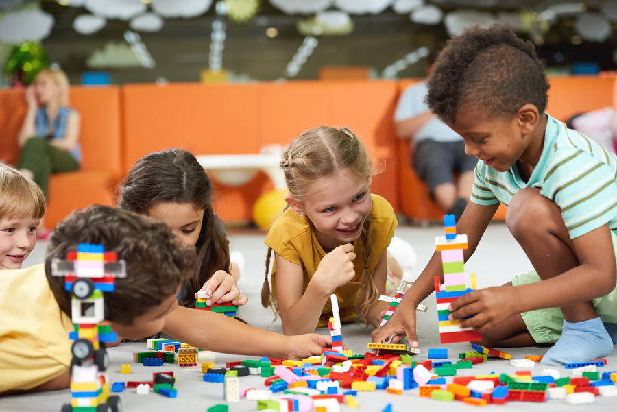 A group of young students learning through play in a preschool classroom.