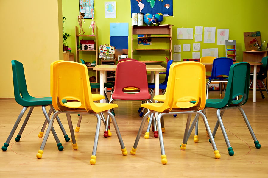 Preschool classroom with colorful chairs in a circle.