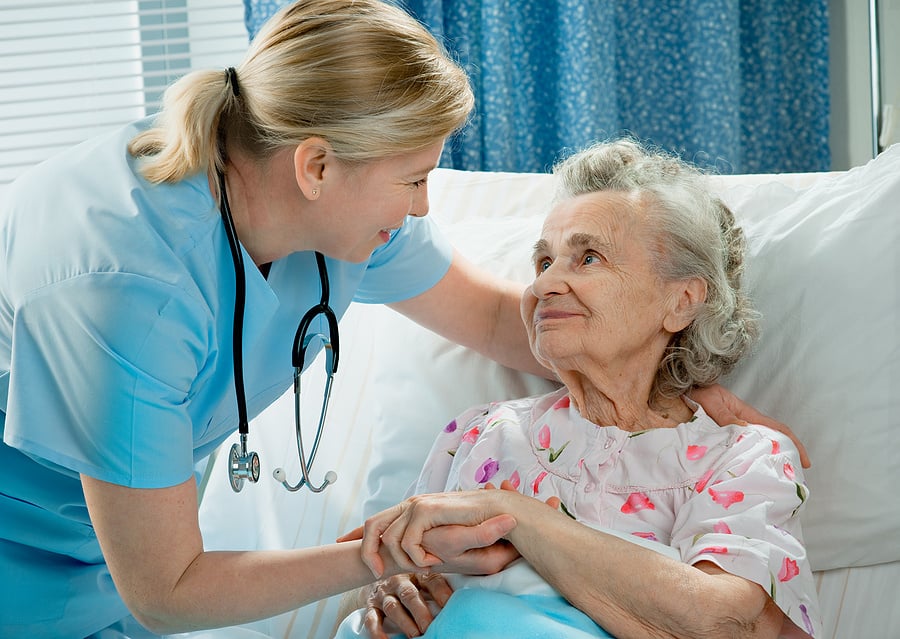 Medical assistant comforting an elderly patient.
