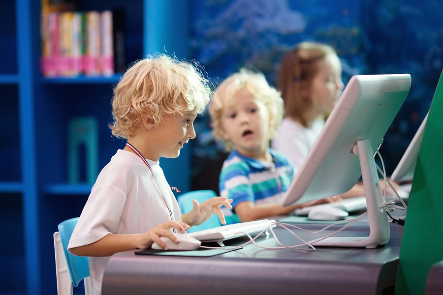 Young children in a classroom on computers.