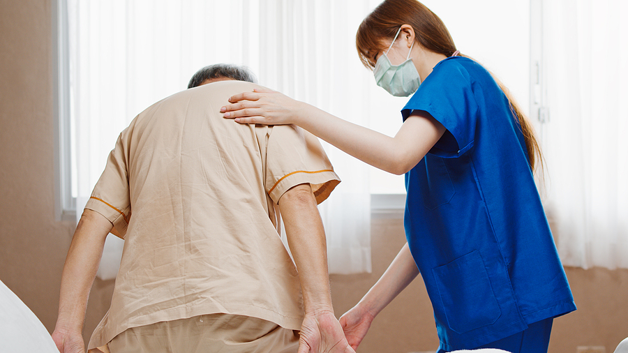 Medical assistant helping an elderly man.