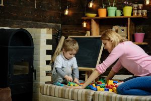 Woman working one on one with a preschool aged boy. 