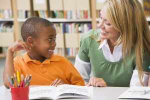 Female teacher working one-on-one with young male student.